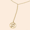 Gold necklace with a circular pendant on a beige background